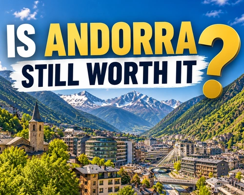 Night view of Andorra la Vella, with illuminated buildings surrounded by the Pyrenees mountains.